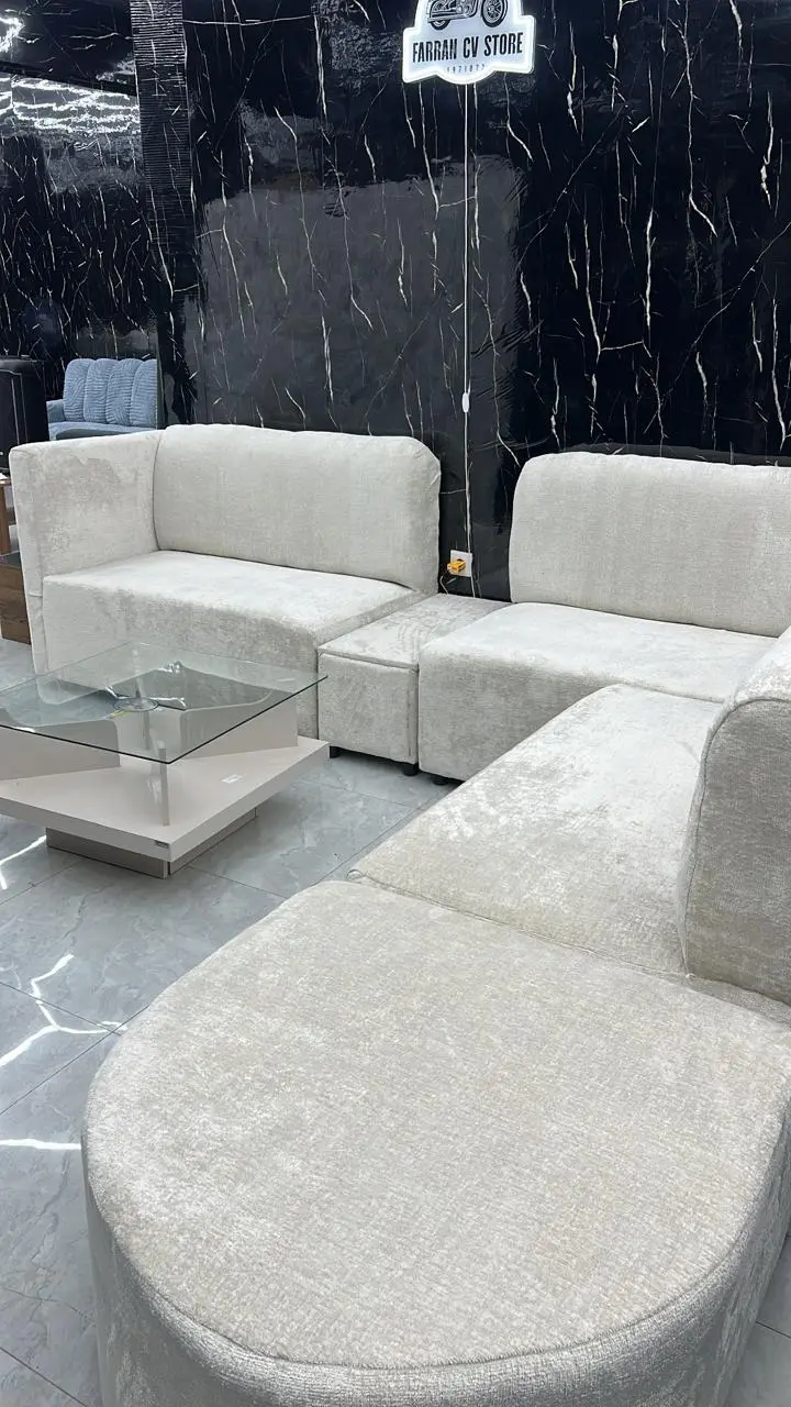 Sofá de canto modular bege-claro com mesa de vidro