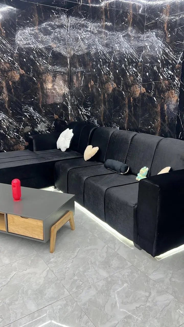 Sofá preto com almofadas e luz LED