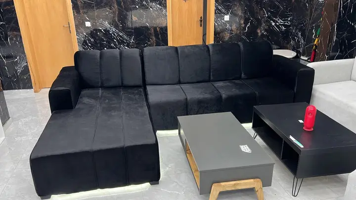Sofá de canto preto com mesas de centro